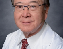 Photo of David Pao in a white lab jacket and red tie.